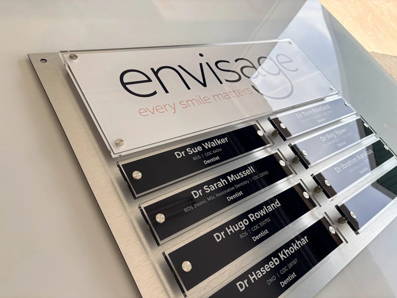 Envisage dental practice directory with clear acrylic nameplates mounted on a brushed metal backing