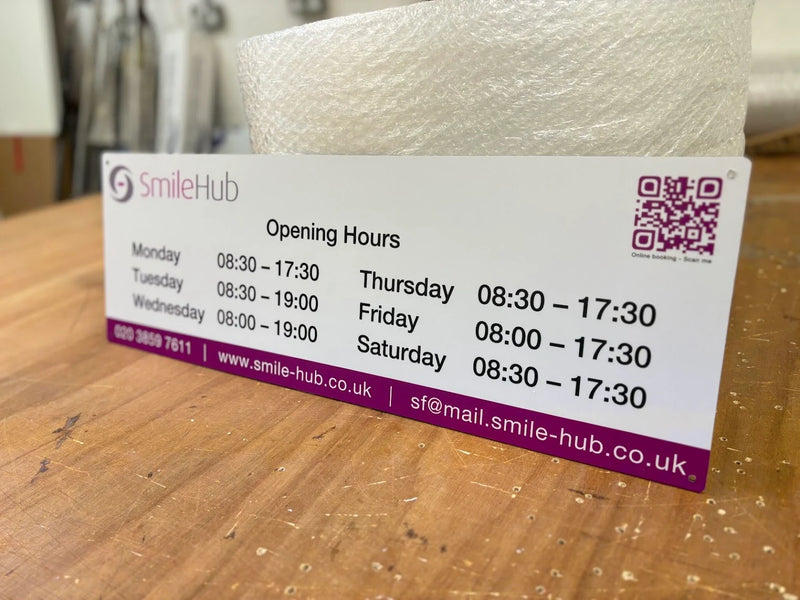 SmileHub dental practice opening hours sign with a purple online booking QR code
